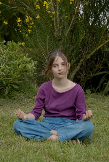 Fillette de 9 ans faisant du yoga dans un jardin
