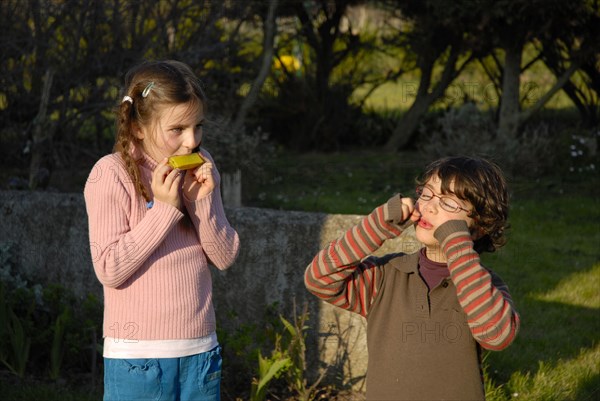 Fillette et garçon jouant dans un jardin