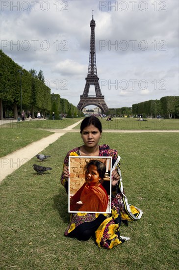 The daughter of Asia Bibi holding the portrait of her mother