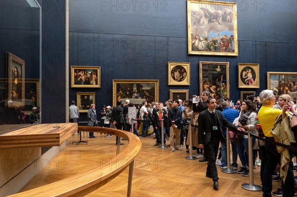 Tourists queuing to take pictures of the Mona Lisa painting by italian artist Leonardo da Vinci at the Louvre Museum in Paris, France, Europe