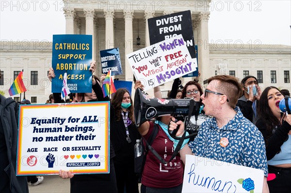 Protesters hold placards reading "Telling women that you won't be free without abortion is mysogyny", "Catholics support abortion access!", and "Equality for ALL human beings, no matter their age, race, sexuality" during an abortion related demonstration in front of the Supreme Court.