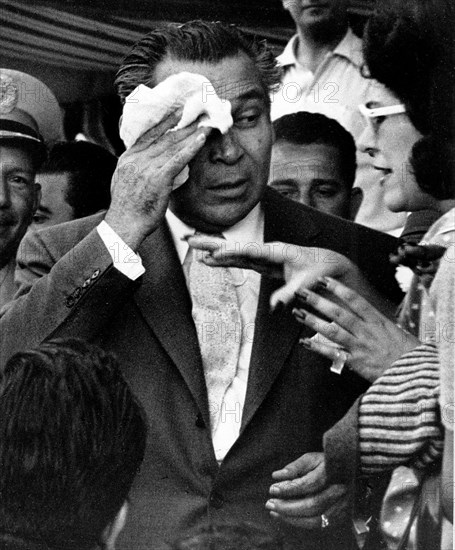 Cuban President Fulgencio Batista wiping his head at a race