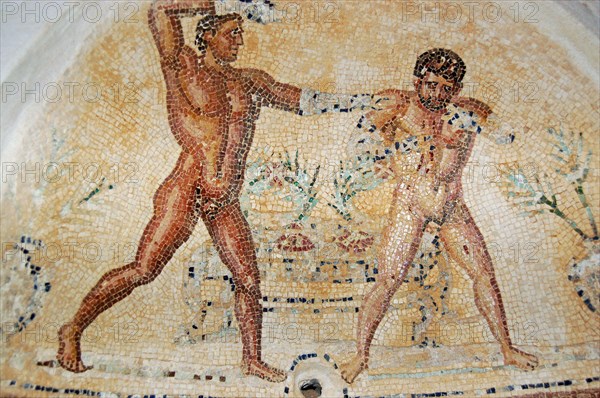 Ancient Roman mosaic showing one man soaping the other.  Arched niche in the baths of the Villa Silene, also known as Villa Celine, in the Khoms area