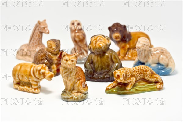 Close up of a collection of Wade Whimsies, small porcelain animal figurines popular with collectors since the 1950s, against a white background.