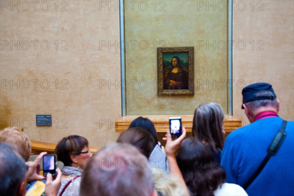 Visitors viewing the Mona Lisa painting in the Louvre Museum in Paris