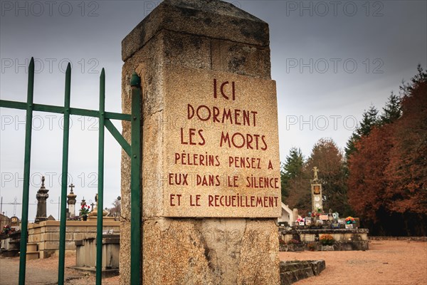 ORADOUR SUR GLANE, FRANCE - December 03, 2017 : at the entrance of the cemetery a stone plaque where it is written - here sleep the dead pilgrims thin