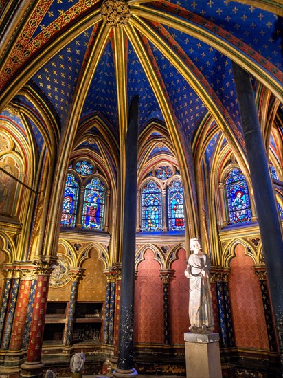 Statue of Saint Louis in Sainte Chapelle: Extravagant arches gilded with gold in a deep blue ceiling frame a statue of Statue of Saint Louis  Louis IX at the front of the lower floor of the famous chapel.