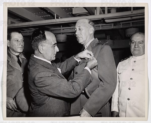 Coast Guard Skipper Decorated by Brazilian President. Coast Guard Captain George W. McKean, Skipper of a troop transport in the Atlantic, is presented with the Medal of Military Merit by President Getulio Vargas of Brazil. The award was made by the Brazilian Government for Captain McKean's safe transporting of elements of the Brazilian Army to the European War Theatre. The troops of the South American republic went overseas aboard a Coast Guard-manned troop transport. Captain McKean's home is at 4122 Vincennes Place, New Orleans, LA.