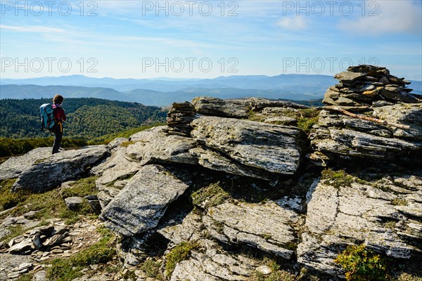 Walker at the summit of Signal de Bougès on the Robert Louis Stevenson Trail in the Cévennes, Lozère, France