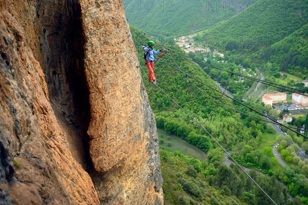 climber on a simple suspension bridge in the rock face, Via ferrata du Rocher de Neuf Heures, France, Provence, Digne-les-Bains