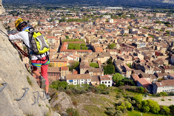 climber on rock wall, town Cavaillon in background, via ferrata de Cavaillon, France, Provence, Cavaillon