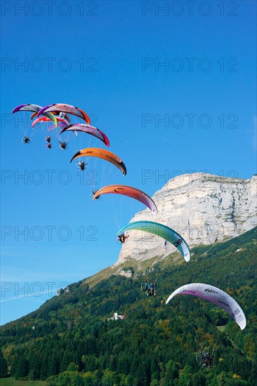 Fleet of nine paramotors flying at the 2017 Coupe Icare event, Dent de Crolles (2062m asl) in the background. Saint-Hilaire du Touvet, Isère, France.