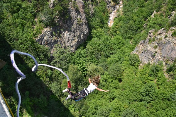 Young woman bungee jumper jumping from a 230 feet high viaduct