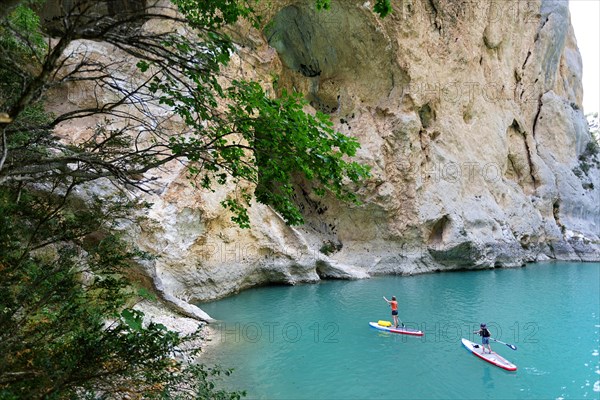 Mother and son paddling on SUP on turquoise water of Gorge du Verdon Provence France