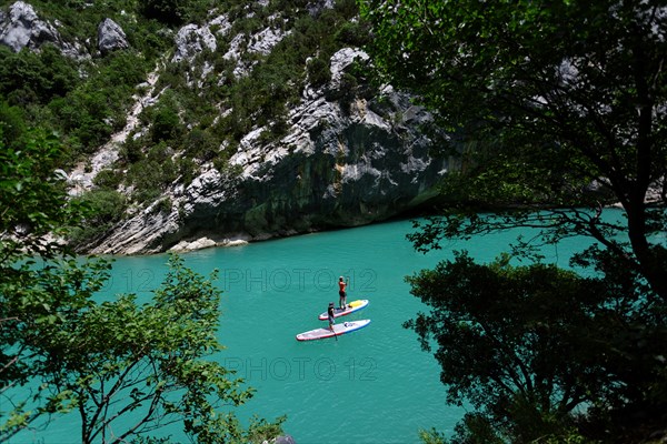 Mother and son paddling on SUP on turquoise water of Gorge du Verdon Provence France