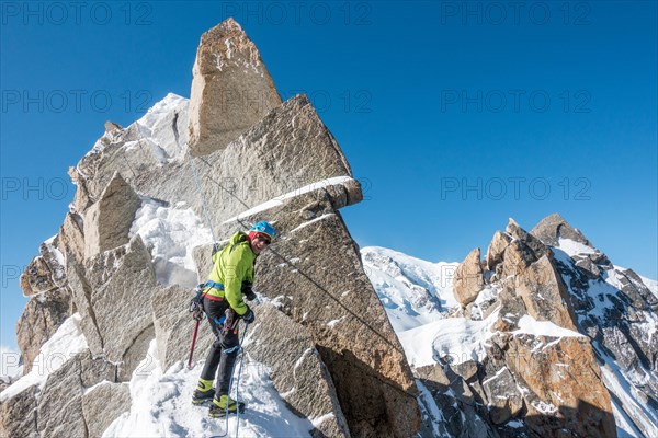 Alpinist rappels a short rock step on the Cosmiques Ridge