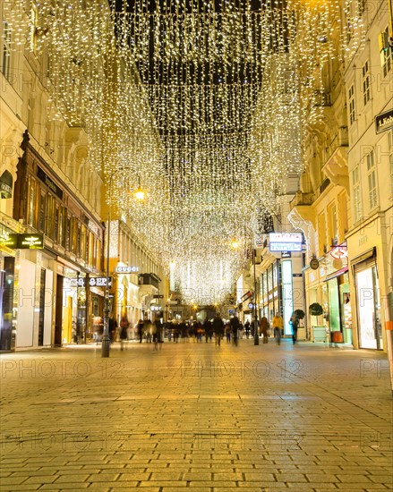 VIENNA, AUSTRIA - 2ND DECEMBER 2015: A view along Kohlmarkt at night during the Christmas season. People can be seen.