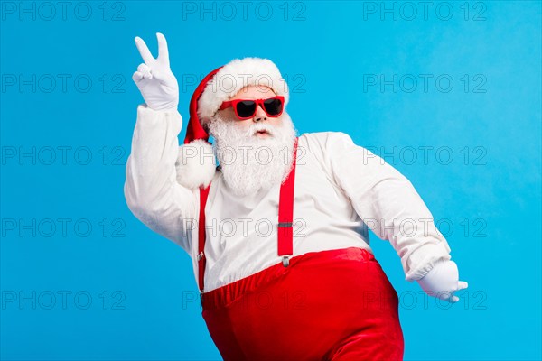 Photo of cool funky overweight santa claus with big belly beard dance x-mas christmas discotheque wear headwear suspenders overalls sunglass isolated