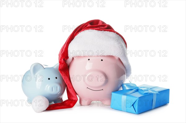 Santa hat with piggy banks and gift box on white background