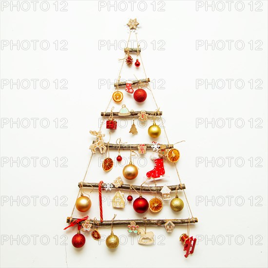 Handmade Christmas tree hangs on a white wall. Alternative decoration, eco-friendly christmas, civic awareness.