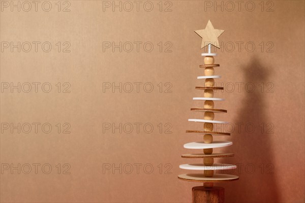 Xmas simple minimalist elegant design with natural elements and copy space for text. Wooden Christmas tree on a wooden background. Eco christmas