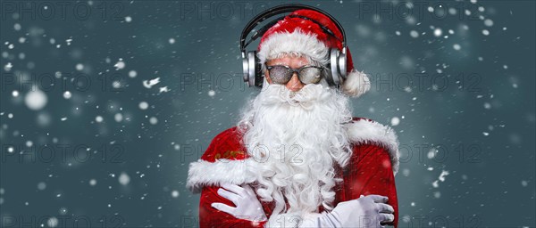 Cool Santa Claus is listening music in headphones