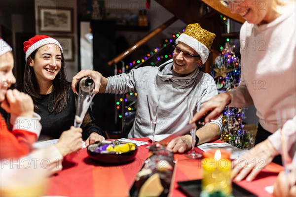 Cheerful multi generational family in Santa Claus celebrating christmas