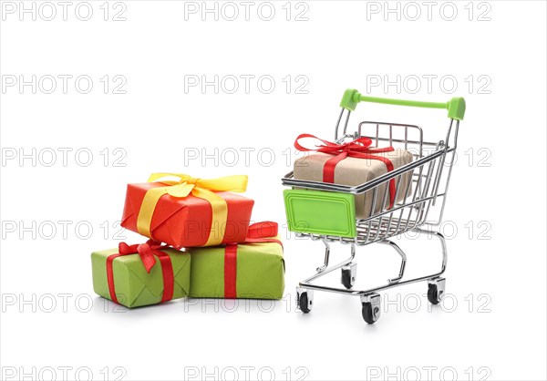 Shopping cart with gift boxes on white background