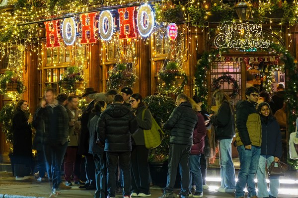 London, UK. 14th November, 2024. The Churchill Arms in Kensington switches on its festive light display with the external walls covered in over 80 Christmas trees and decorations. The pub attracts many visitors with its impressive seasonal floral and plant displays all year round.  Credit: Eleventh Hour Photography/Alamy Live News