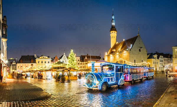 Beautiful Train for sightseeing near Traditional Christmas Market On Town Hall Square - Raekoja Plats In Tallinn, Estonia. Christmas Tree And Trading