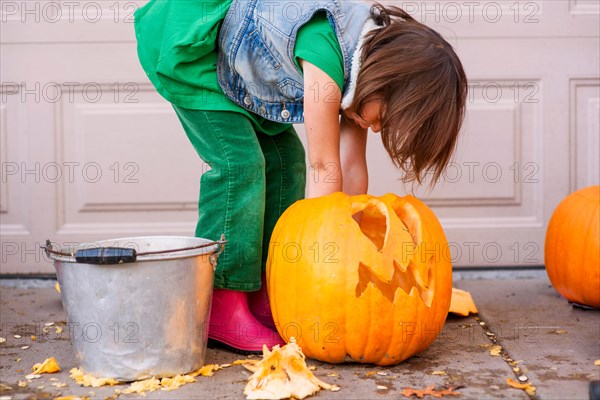 Girl carving a Halloween pumpkin