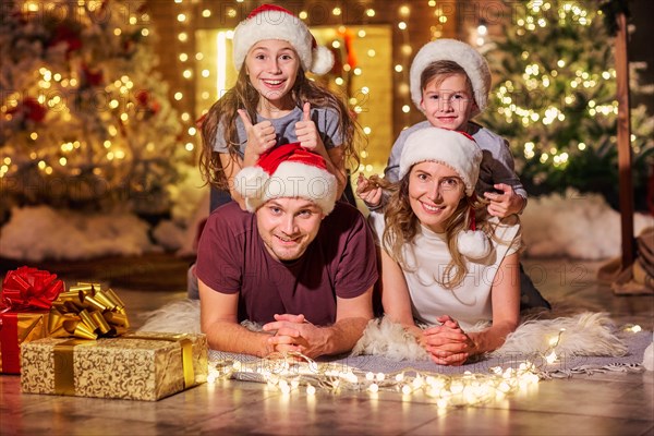 Happy family in a room with a Christmas tree.