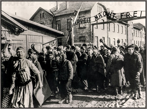 Auschwitz-Birkenau prisoners celebrate their liberation by Russian Soviet Army troops 26th January 1945, behind them the infamous Nazi extermination & concentration camp entrance sign “ARBEIT MACHT FREI”. Work sets you free. WW2 World War II Second World War Former Nazi Occupied Poland