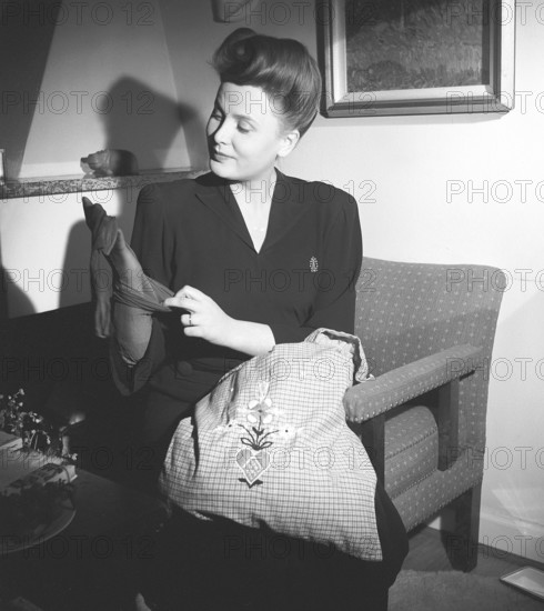 Nylon stockings in the 1940s. A young woman is holding a nylon stocking in her hand. The nylon stocking was very popular in the 1940s, a trendy accessory that was very expensive to buy during time of world war II. She is actress Birgit Tengroth, 1915-1983.  Sweden 1944. Photo Kristoffersson ref G85-4