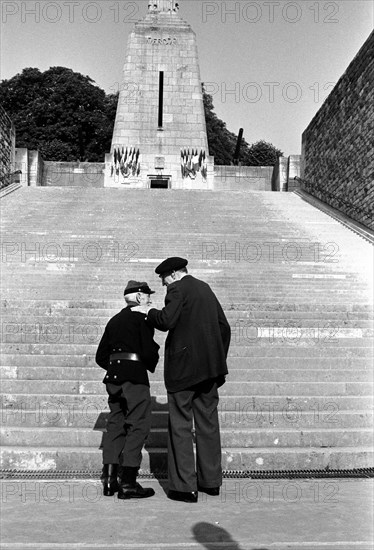 Anciens combattants standing by a war memorial at Verdun, France