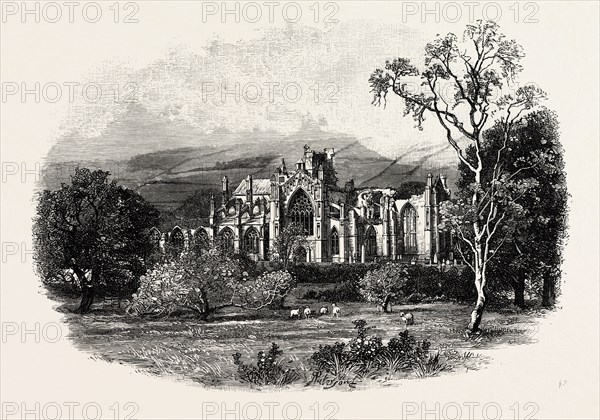 MELROSE ABBEY, FROM THE SOUTH-EAST. Melrose Abbey is a Gothic-style abbey in Melrose, Scotland. It was founded in 1136 by Cistercian monks, on the request of King David I of Scotland. It was headed by the Abbot or Commendator of Melrose. UK