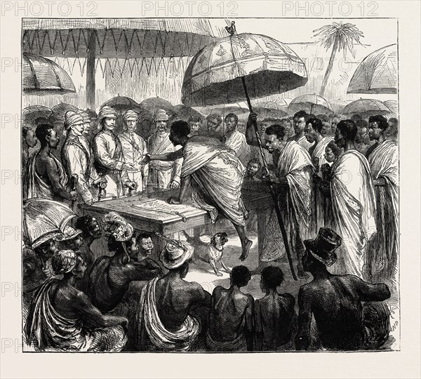 THE ASHANTEE WAR, READING THE QUEEN'S LETTER AT THE PALAVER OF KINGS AT ACCRA, GHANA: ATTAH, KING OF AKIM, AND THE GORDON SETTER, 1873 engraving