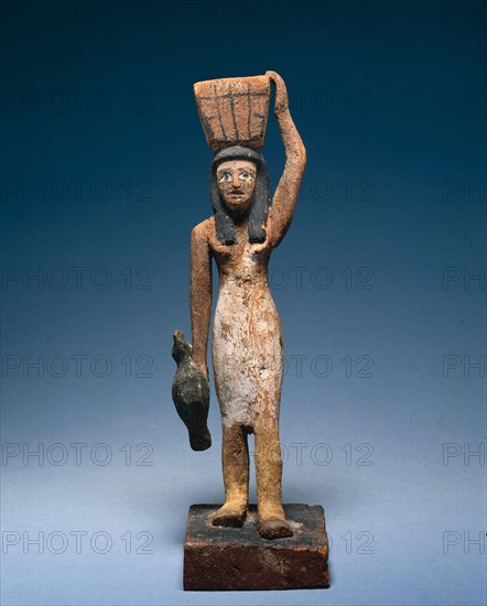 Female Offering Bearer, 2000-1801 BC. Egypt, Middle Kingdom, late Dynasty 11 to early Dynasty 12. Painted wood, figure of tamarisk (?), base of sycamore fig; overall: 25.8 x 7.9 x 12.2 cm (10 3/16 x 3 1/8 x 4 13/16 in.).