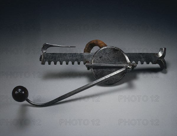 Cranequin, c. 1580. Germany, Nuremberg (?), 16th century. Steel, flax cord, wooden handle; rack: 36.3 cm (14 5/16 in.); crank: 30.5 cm (12 in.); gear housing: 10.8 cm (4 1/4 in.).