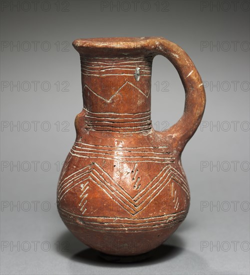Jug, 2000-1800 BC. Cyprus, Early Cypriot III-Middle Cypriot II. Red ware; diameter: 4.3 cm (1 11/16 in.); overall: 10.8 x 6.8 cm (4 1/4 x 2 11/16 in.).
