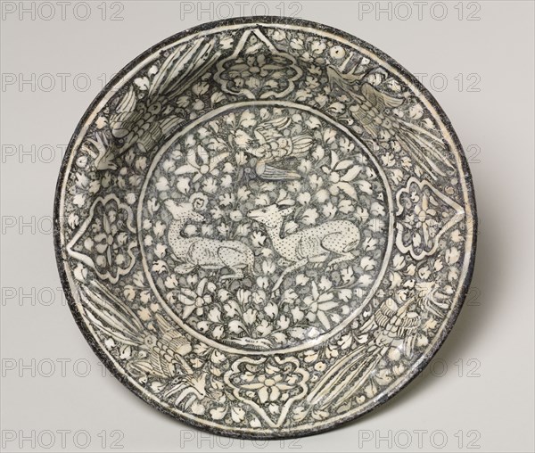 Ceramic dish with deer, phoenix, and lotus blossoms, 1300-1350. Iran, Sultanabad. Fritware with underglaze-painted design; overall: 7 x 32.6 cm (2 3/4 x 12 13/16 in.).