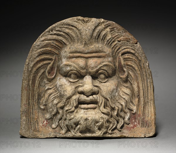 Antefix with Satyr Face, 370-330 BC. Italy, mid-4th Century BC. Terracotta; overall: 17.1 cm (6 3/4 in.).