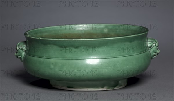 Bowl in Form of Archaic Gui, 1628-1661. China, Jiangxi province, Jingdezhen, Ming dynasty, Jiajing mark (1522-1566) but Chongzhen period (1628-1644) or Qing dynasty, Shunzhi period (1644-1661). Porcelain with camellia-leaf green glaze; diameter: 23.4 cm (9 3/16 in.); overall: 9 cm (3 9/16 in.).