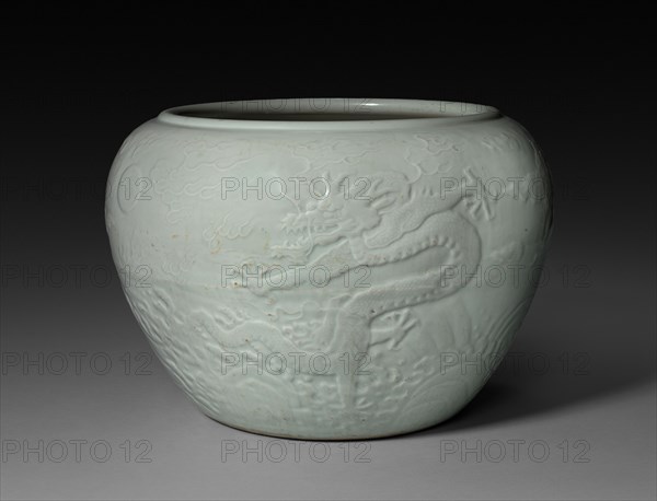 Jardiniere with Dragon in Waves, 1662-1722. China, Jiangxi province, Jingdezhen kilns, Qing dynasty (1644-1912), Kangxi reign (1661-1722). Porcelain with molded and incised decoration and light celadon glaze; diameter: 41.7 cm (16 7/16 in.); overall: 28.2 cm (11 1/8 in.).