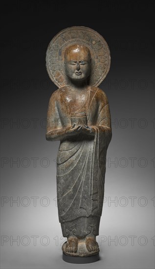 Standing Disciple Mahakasyapa Holding a Cylindrical Reliquary, c. 550. China, Hebei province, Southern Xiangtangshan caves, Northern Qi dynasty (550-577). Limestone with traces of pigment; overall: 116 x 33 x 25 cm (45 11/16 x 13 x 9 13/16 in.).