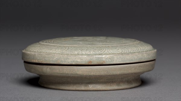 Covered Box: Yue Ware, 907-960. China, Shang-lin-hu kilns, Yu-yao District, Zhejiang province, Five dynasties (907-960). Glazed stoneware with incised decoration; diameter: 13 cm (5 1/8 in.); overall: 4.5 cm (1 3/4 in.).