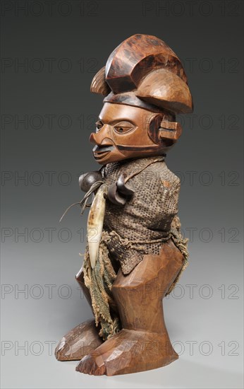 Figure, late 1800s-mid 1900s. Central Africa, Democratic Repulic of the Congo, late 19th-mid 20th Century. Wood, lizard skin, leopard tooth, seed pods, cloth; overall: 23 cm (9 1/16 in.)