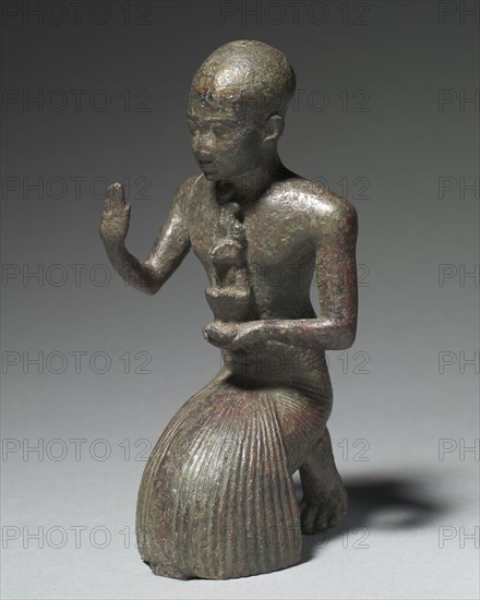 Statuette of a Kneeling Priest, 1186-1069 BC. Egypt, New Kingdom, Dynasty 20, 1279-1213 BC. Tin-bronze alloy, probably leaded, hollow cast; overall: 15.8 x 6.2 x 6.5 cm (6 1/4 x 2 7/16 x 2 9/16 in.)