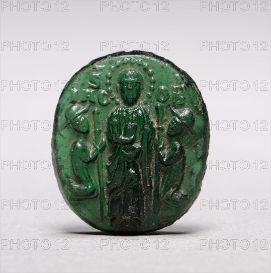 Devotional Badge with Saint James Flanked by Two Kneeling Pilgrims, c. 1200-1250. Italy, Venice, 13th century. Molded green glass; overall: 2.9 x 2.6 cm (1 1/8 x 1 in.)