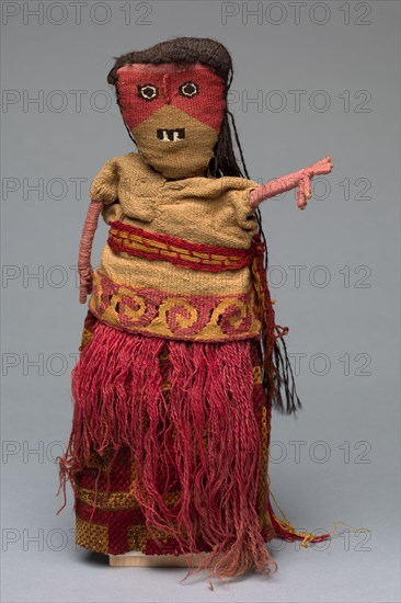 Male Figure with Modern Additions, 1100-1500. Peru, Central Coast, Chancay people. Original elements include the head and tunic; added elements include the skirt, red fringe, and belt; Cotton, camelid fiber, reeds; Slit tapestry (tunic and face); plain weave with supplementary weft (skirt); overall: 30.5 x 15.2 x 10 cm (12 x 6 x 3 15/16 in.)